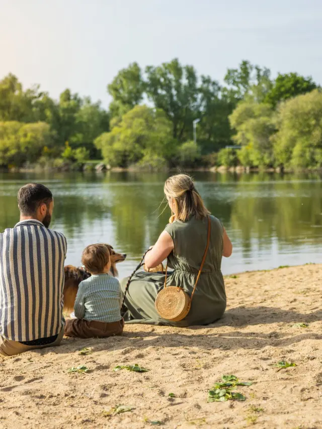 Famille assise sur la petite plage de la base de loisirs de Saint-Lyphard