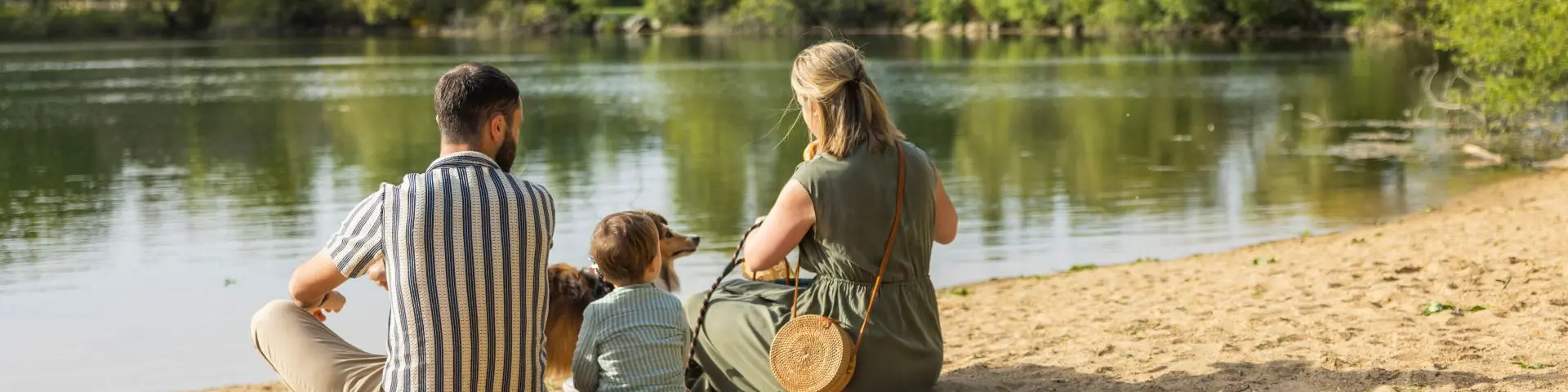 Famille assise sur la petite plage de la base de loisirs de Saint-Lyphard