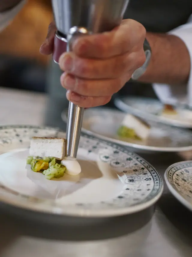 Chef qui fait une emulsion dans une belle assiette dans le cadre de l'événement Saveurs d'octobre