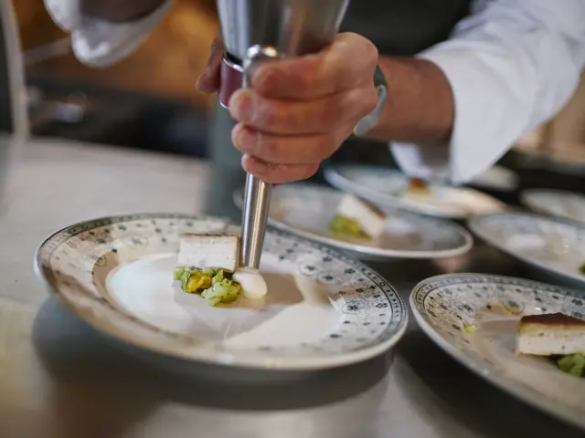 Chef qui fait une emulsion dans une belle assiette dans le cadre de l'événement Saveurs d'octobre