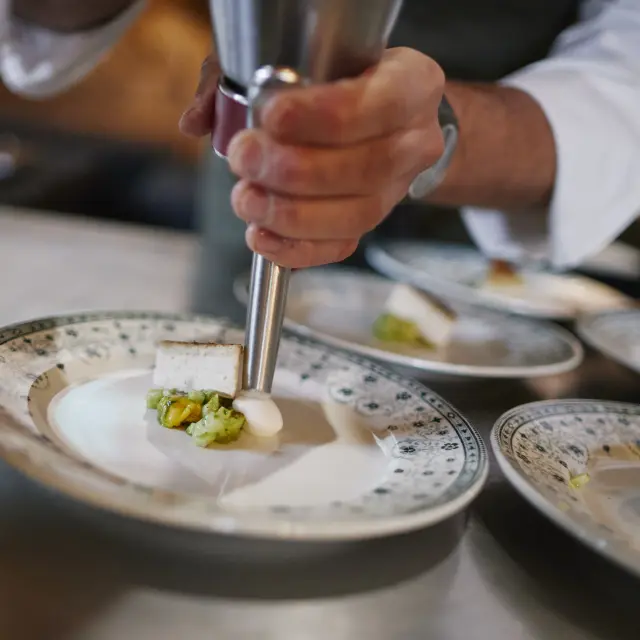 Chef qui fait une emulsion dans une belle assiette dans le cadre de l'événement Saveurs d'octobre