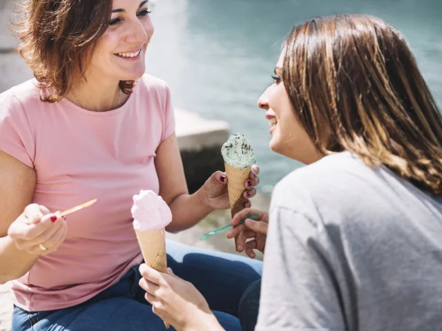 Donne che mangiano il gelato vicino al mare
