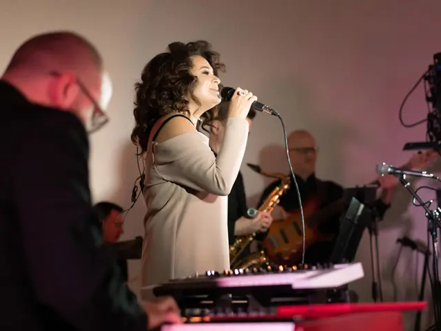 Una joven y guapa cantante en el escenario cantando por el micrófono