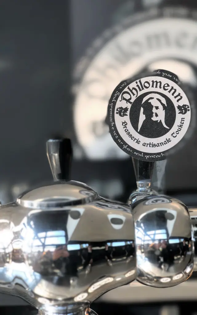 Une tireuse à bière chromée avec le logo de la Brasserie Philomenn