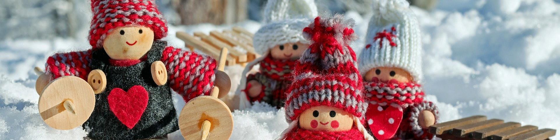 Un décoration de Noël faite de petits personnages en laine dans un décor enneigé