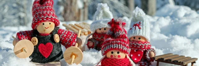 Un décoration de Noël faite de petits personnages en laine dans un décor enneigé