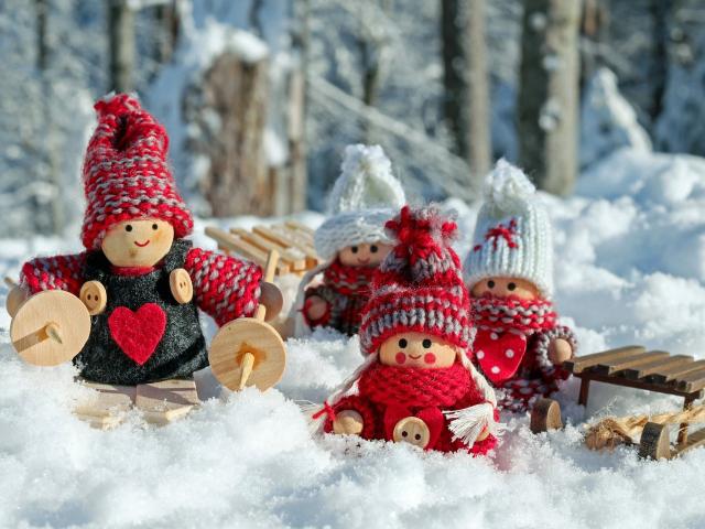 Un décoration de Noël faite de petits personnages en laine dans un décor enneigé