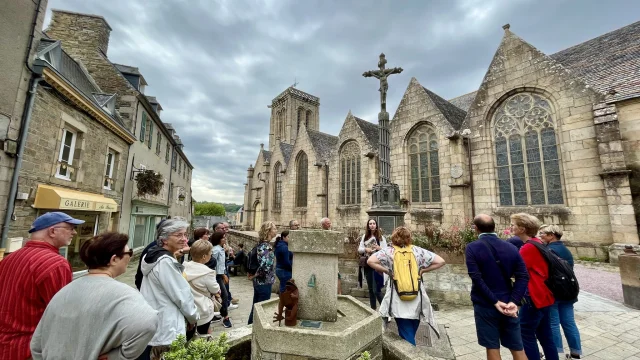 Ella, guide conférencier accompagne un groupe devant l'église Saint-Jean-du-Baly pour une visite guidée de Lannion