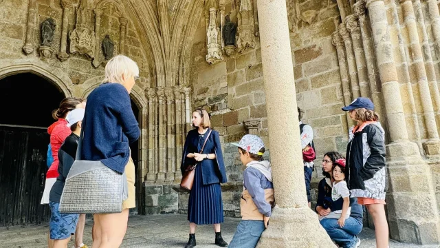 Balade ludique de Tréguier. La guide lance l'intrigue de la visite sous un porche de la cathédrale Saint-Tugdual
