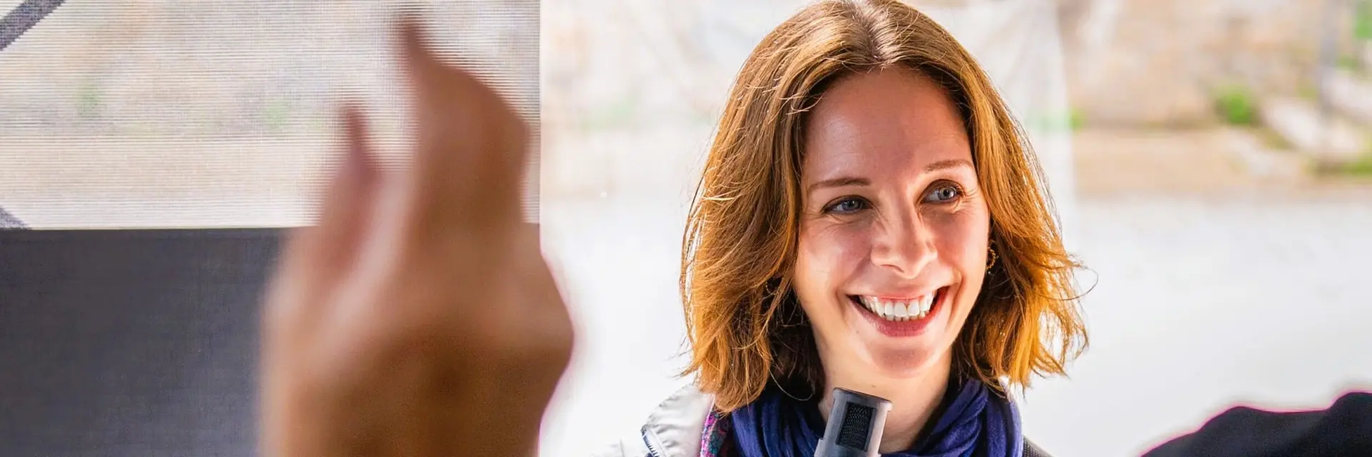 Une guide-conférencière au micro devant un groupe de touristes durant une visite guidée