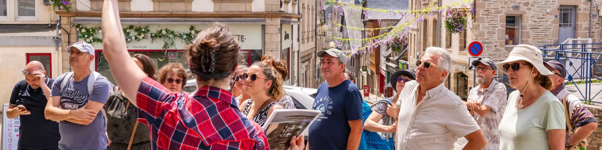 Une guide montre un monument de Lannion à des touristes dans Lannion