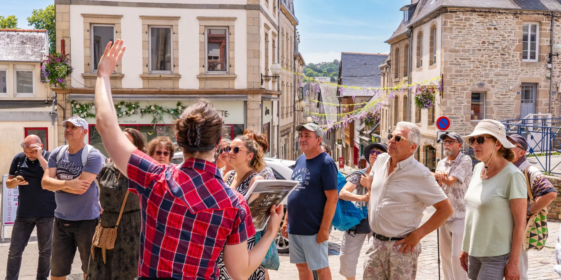 Une guide montre un monument de Lannion à des touristes dans Lannion