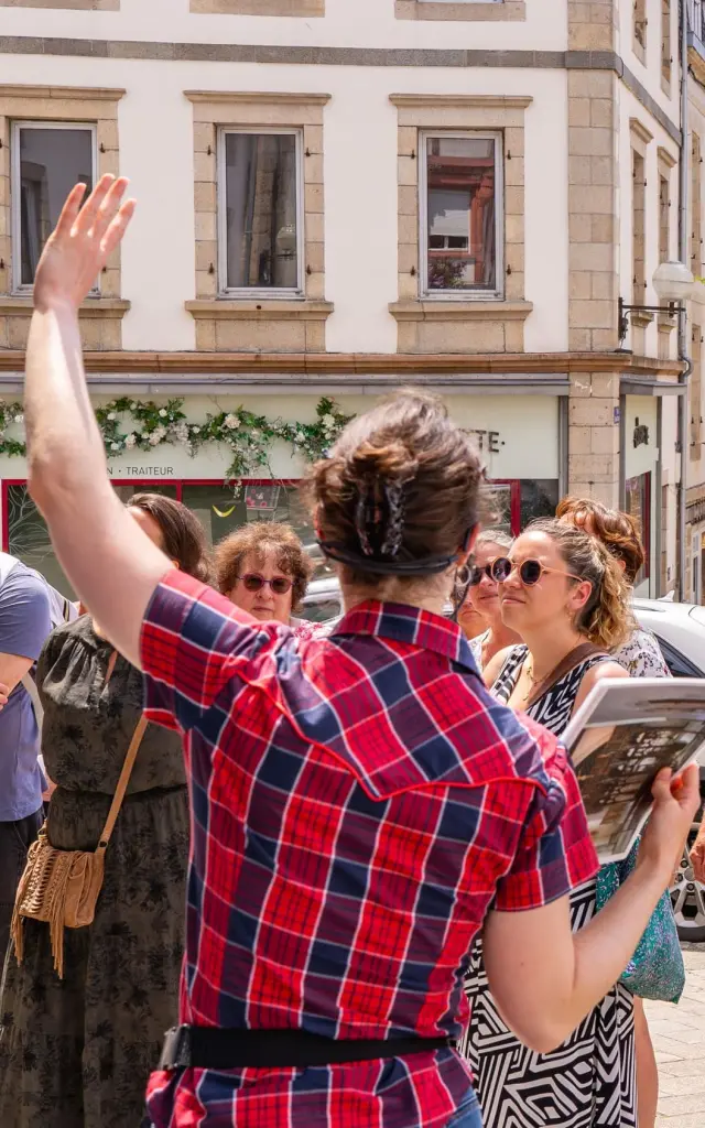 Une guide montre un monument de Lannion à des touristes dans Lannion