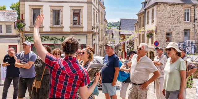 Une guide montre un monument de Lannion à des touristes dans Lannion