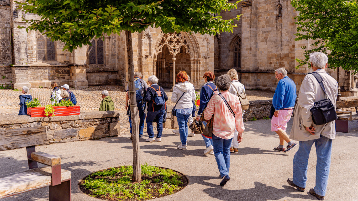 Un groupe de personne en visite guidée devant la Cathédrale de Tréguier