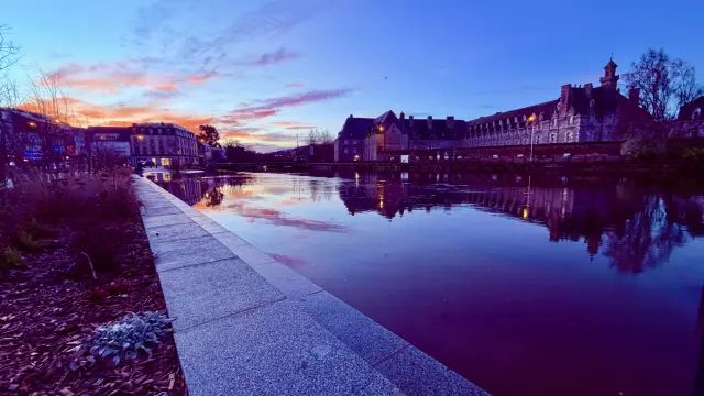 Marée haute sur le Quai d'Aiguillon à Lannion à l'aube, le ciel est rose et bleu.