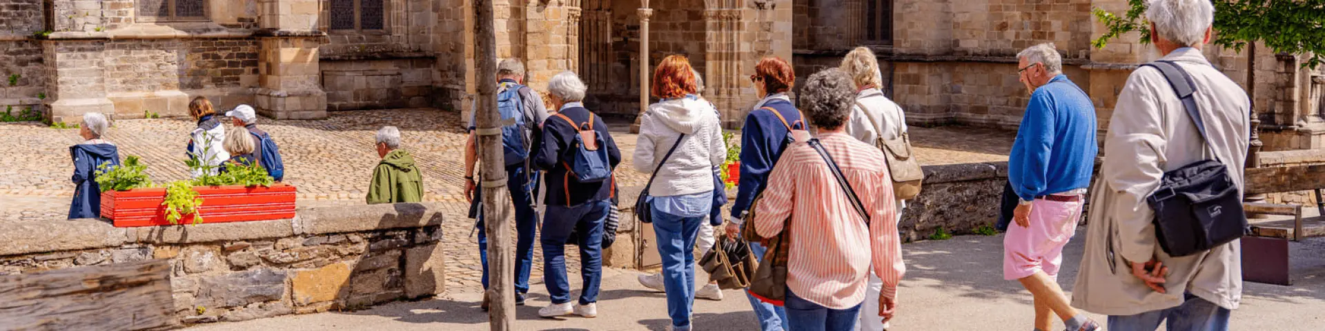 Un groupe de personne en visite guidée devant la Cathédrale de Tréguier