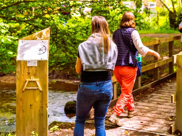 Des personnes se baladent sur un chemin et un petit pont de bois à Plouaret.