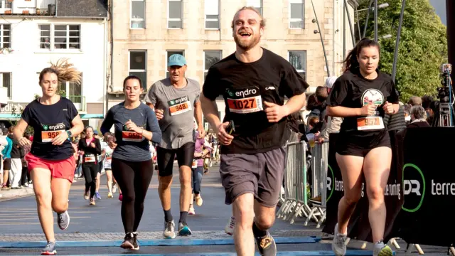 Des coureurs à pied passe l'arrivée d'un course