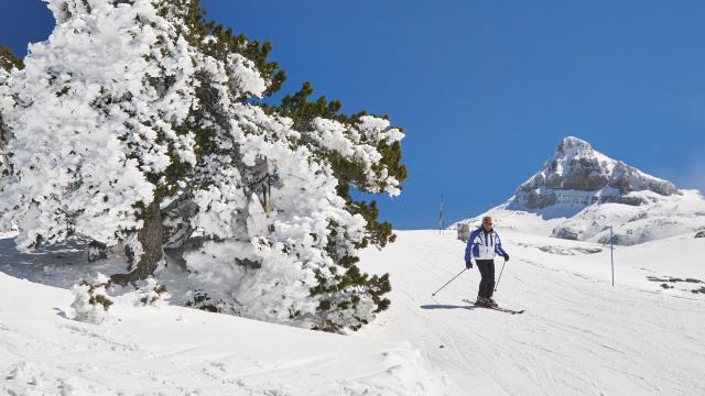 Skieur profitant du paysage sur le boulevard des Pyrénées à la Pierre Saint-Martin, en arrière plan le pic d'Anie