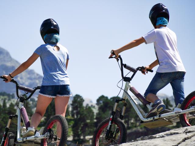 Enfants en trottinettes, face au pic d'Anie, durant la saison été à La Pierre Saint-Martin (Pyrénées béarnaises)