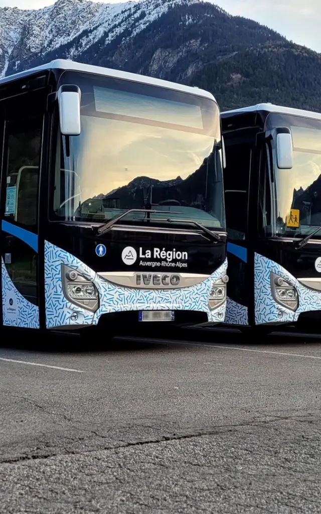 Bus de tourisme blanc et bleu avec logo Cityliner garé sur un parking en montagne