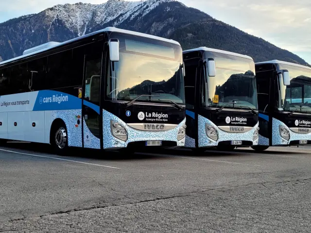Bus de tourisme blanc et bleu avec logo Cityliner garé sur un parking en montagne