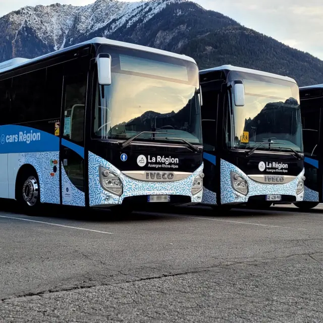 Bus de tourisme blanc et bleu avec logo Cityliner garé sur un parking en montagne