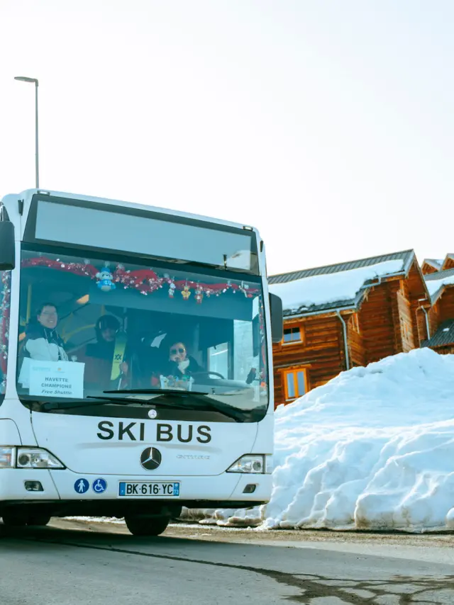 Bus blanc marqué 'Ski Bus' transportant des skieurs sur la station de La Toussuire