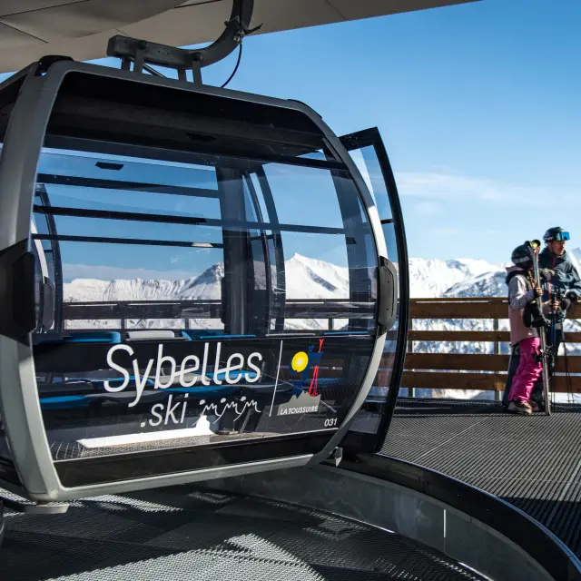 Télécabine Côte di Bois transportant des passagers en montagne, avec vue sur les pistes et les sommets enneigés