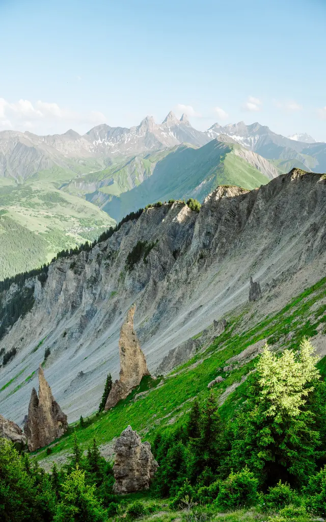 Vue des colonnes de fées du Mont Charvin entouré esde falaises rocheuses et de sommets enneigés