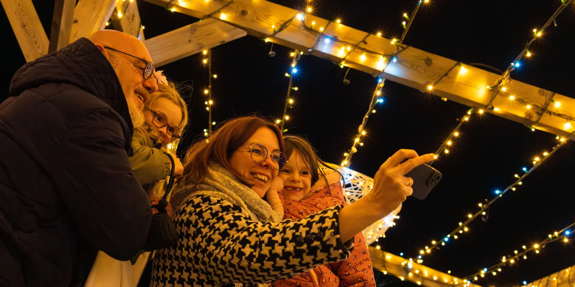 Famille se prenant en photo aux illuminations de Laval en 2024.