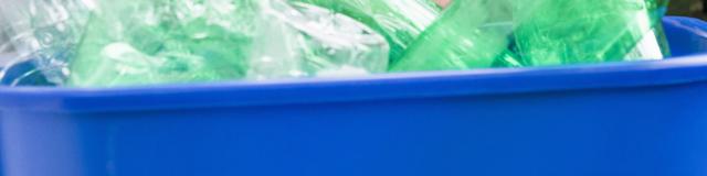 Woman hiding behind recycling bin