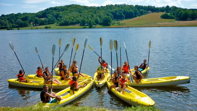 Groupe d’enfants et ados en canoë sur le lac du Tolerme lors d’une animation estivale au Village Club & Spa Terrou