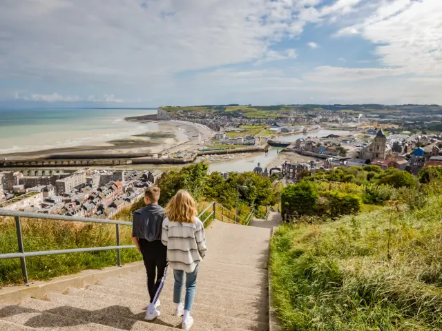 Couple empruntant les escaliers de la falaise du Tréport pour descendre vers le centre-ville