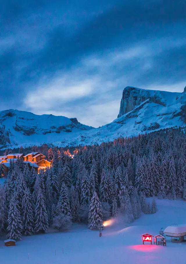 La station de ski de Superdévoluy sous la neige de nuit avec en fond le Pic de Bure, dans les Hautes-Alpes.