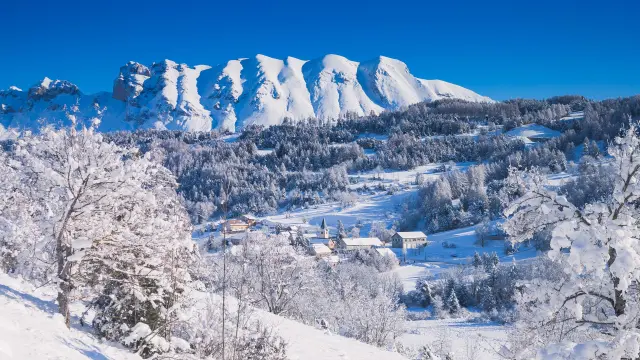 Het besneeuwde dorp Agnières-en-Dévoluy met zijn kerk aan de voet van de bergen van de Dévoluy, in de Hautes-Alpes.