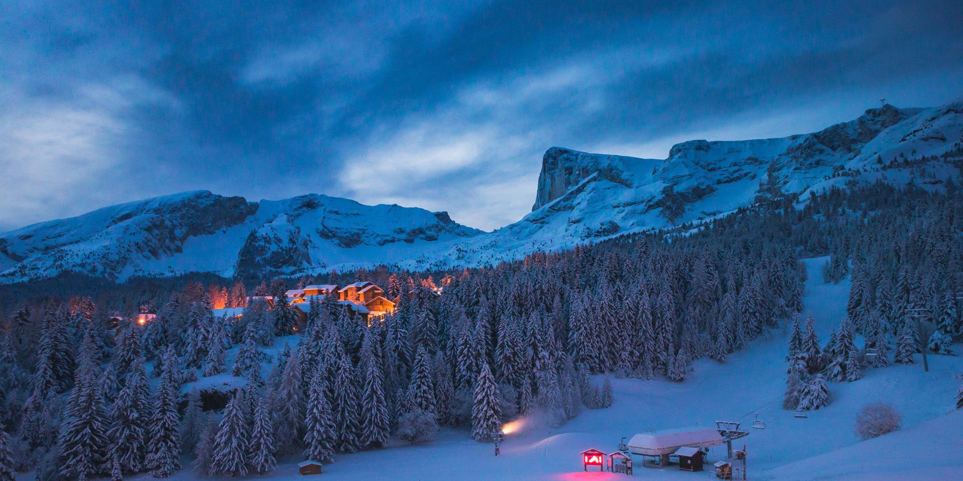 La station de ski de Superdévoluy sous la neige de nuit avec en fond le Pic de Bure, dans les Hautes Alpes