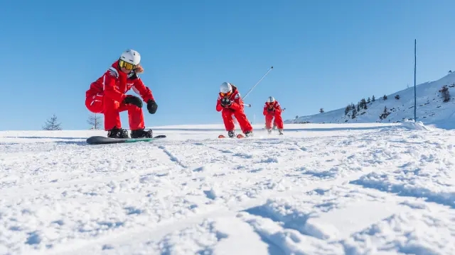 Moniteurs de l’ESF en tenue rouge réalisant une démonstration de ski sur une piste enneigée au Dévoluy.