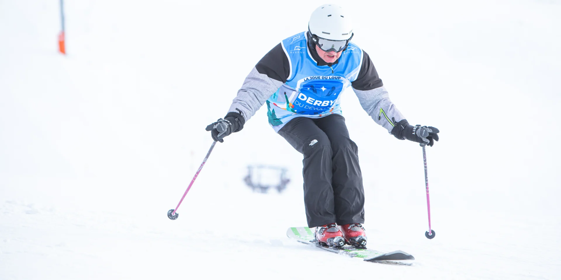 Un skieur en monoski descendant une piste.