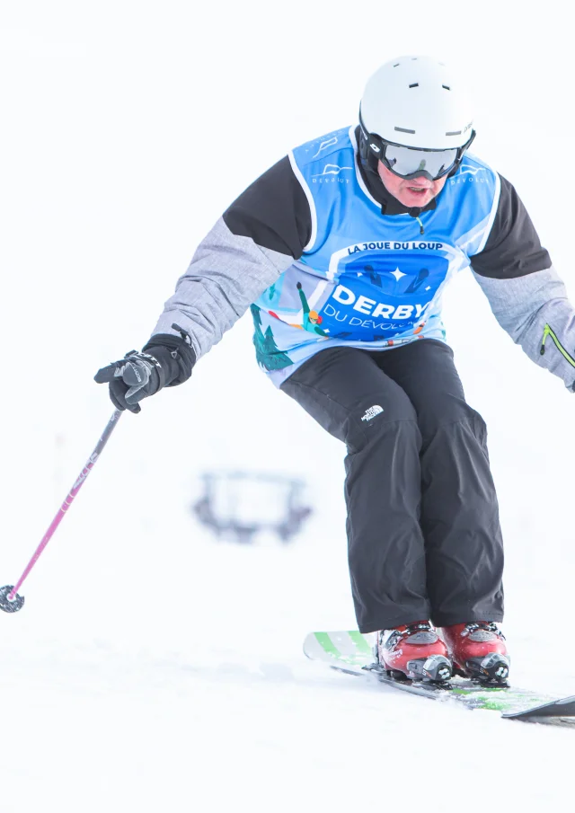 Un skieur en monoski descendant une piste.