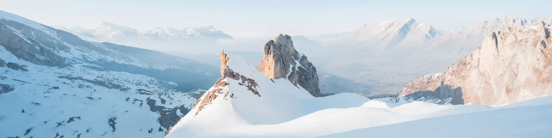 Besneeuwde bergkam van de Vallon d'Âne in het Dévoluy-massief, met rotsachtige toppen die onder een helderblauwe hemel uit de sneeuw oprijzen.