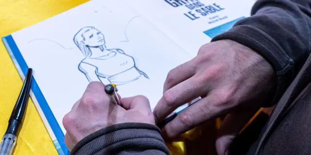 Een striptekenaar maakt live een illustratie tijdens Les Givrés de la BD in Le Dévoluy.