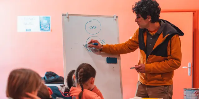 Een striptekenaar geeft een tekenworkshop aan kinderen tijdens Les Givrés de la BD in Le Dévoluy.