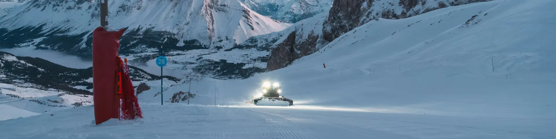 Dameuse préparant une piste de ski au lever du jour sur le domaine alpin du Dévoluy, en montagne.
