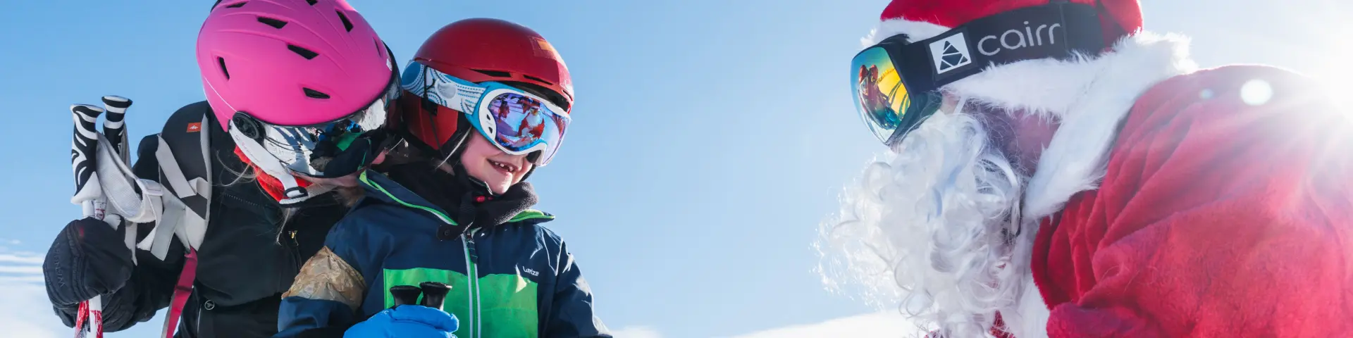 Een kind op ski’s ontmoet de Kerstman op de besneeuwde pistes van Le Dévoluy.