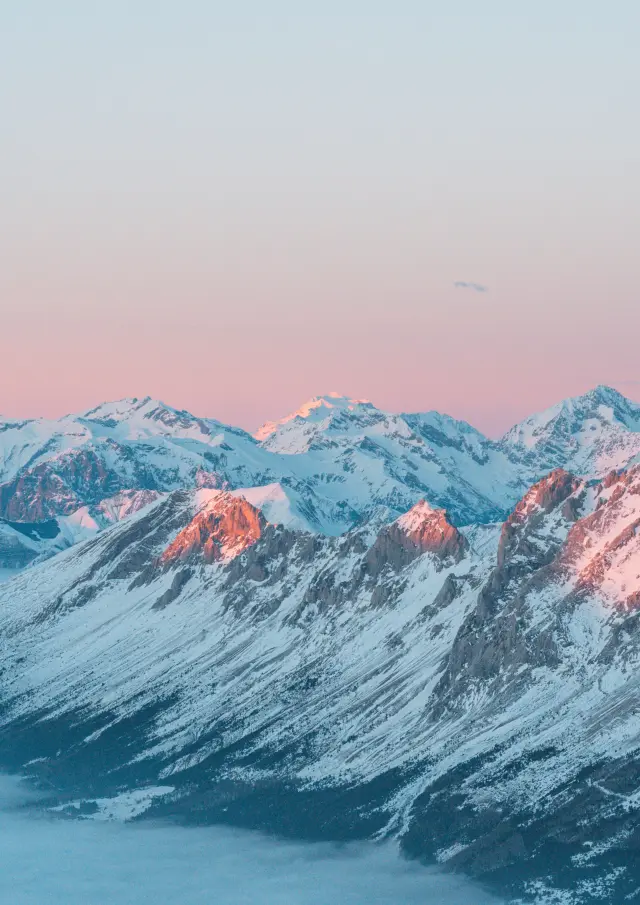 Une mer de nuages face aux sommets alpins au coucher de soleil depuis le plateau de Bure dans Le Dévoluy.