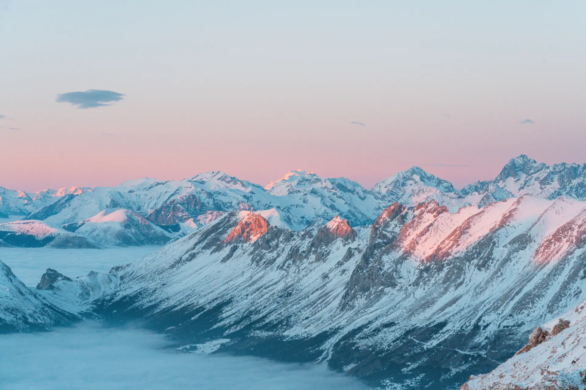 Une mer de nuages face aux sommets alpins au coucher de soleil depuis le plateau de Bure dans Le Dévoluy.