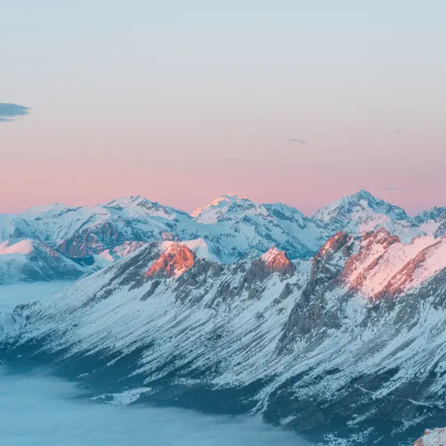 Une mer de nuages face aux sommets alpins au coucher de soleil depuis le plateau de Bure dans Le Dévoluy.