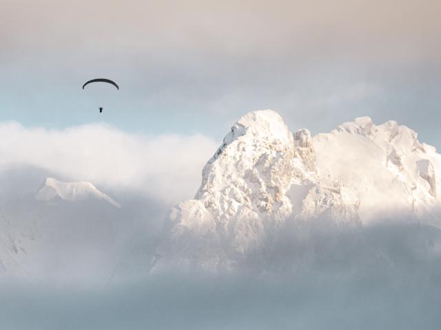 Parapentiste volant au-dessus des sommets de la chaîne des Aravis